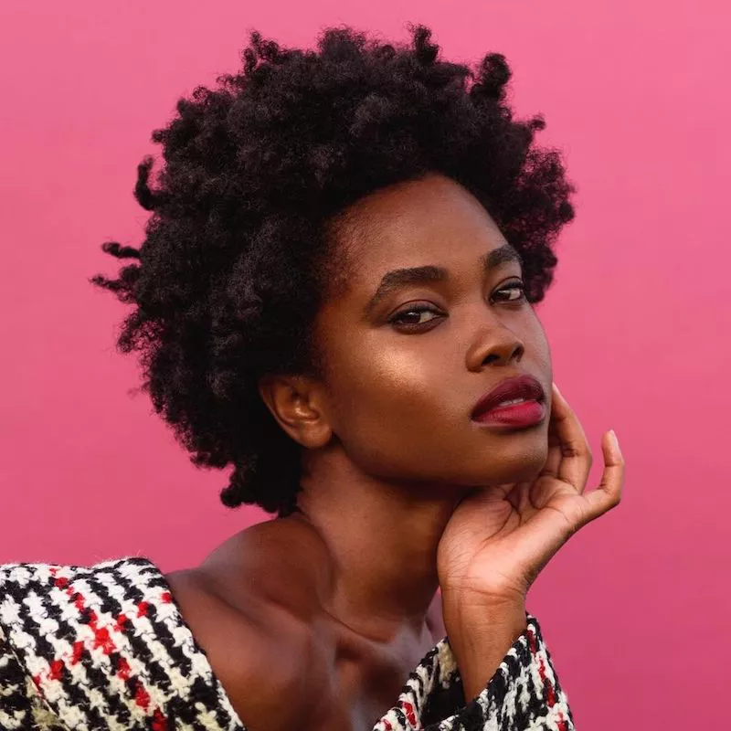 Model wears a natural Afro hairstyle