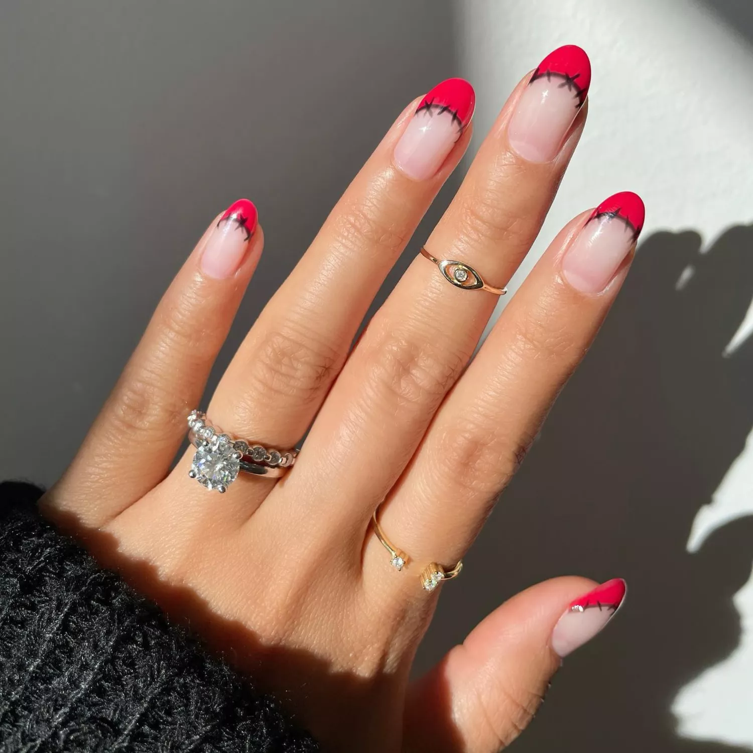 Red french tip nails with black sewing cross stitch details. 