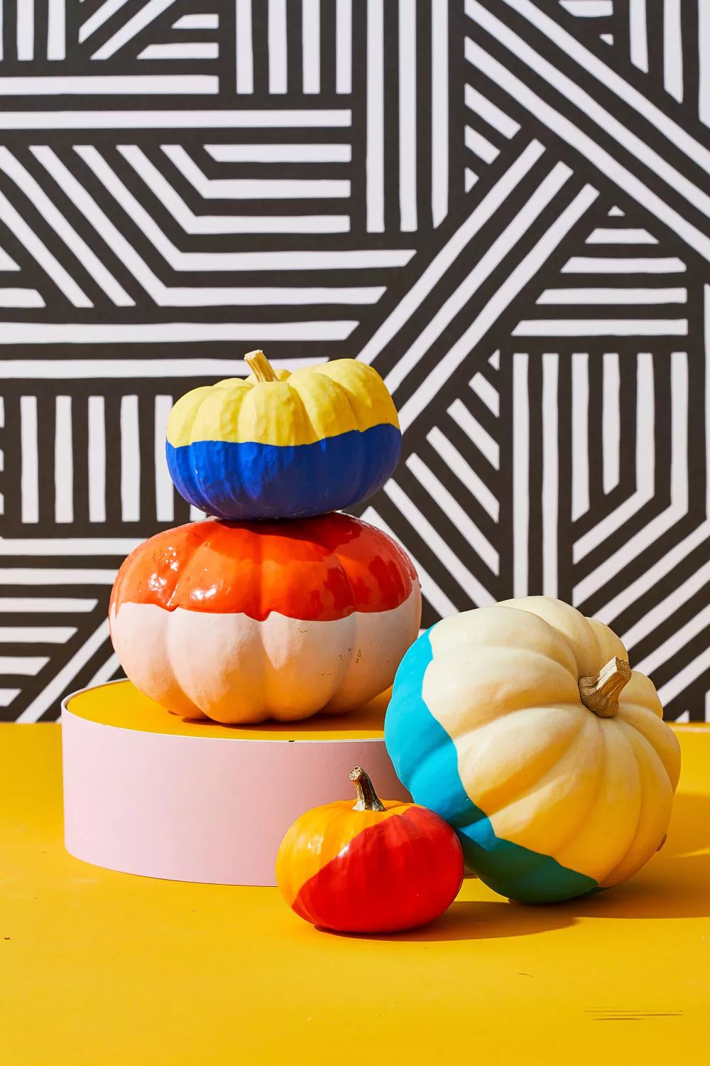 Four painted pumpkins on pedestal