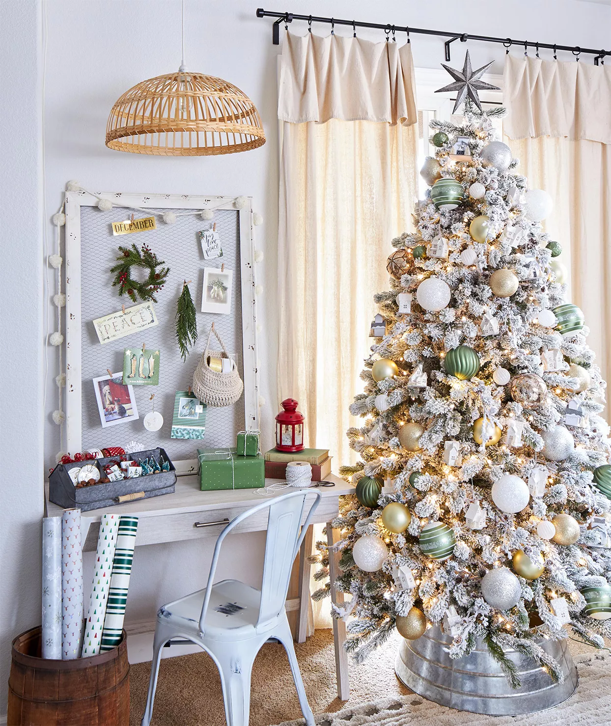 white christmas tree with green and metallic ornaments next to desk