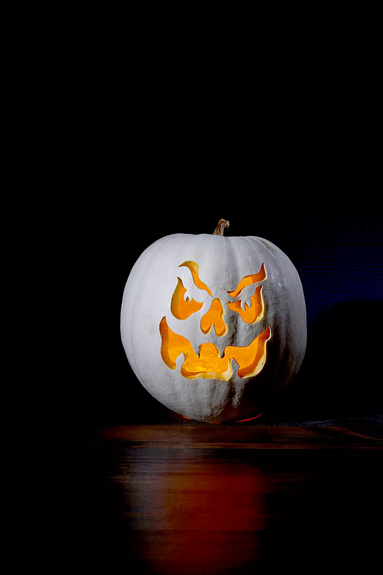 White pumpkin with scary face carving