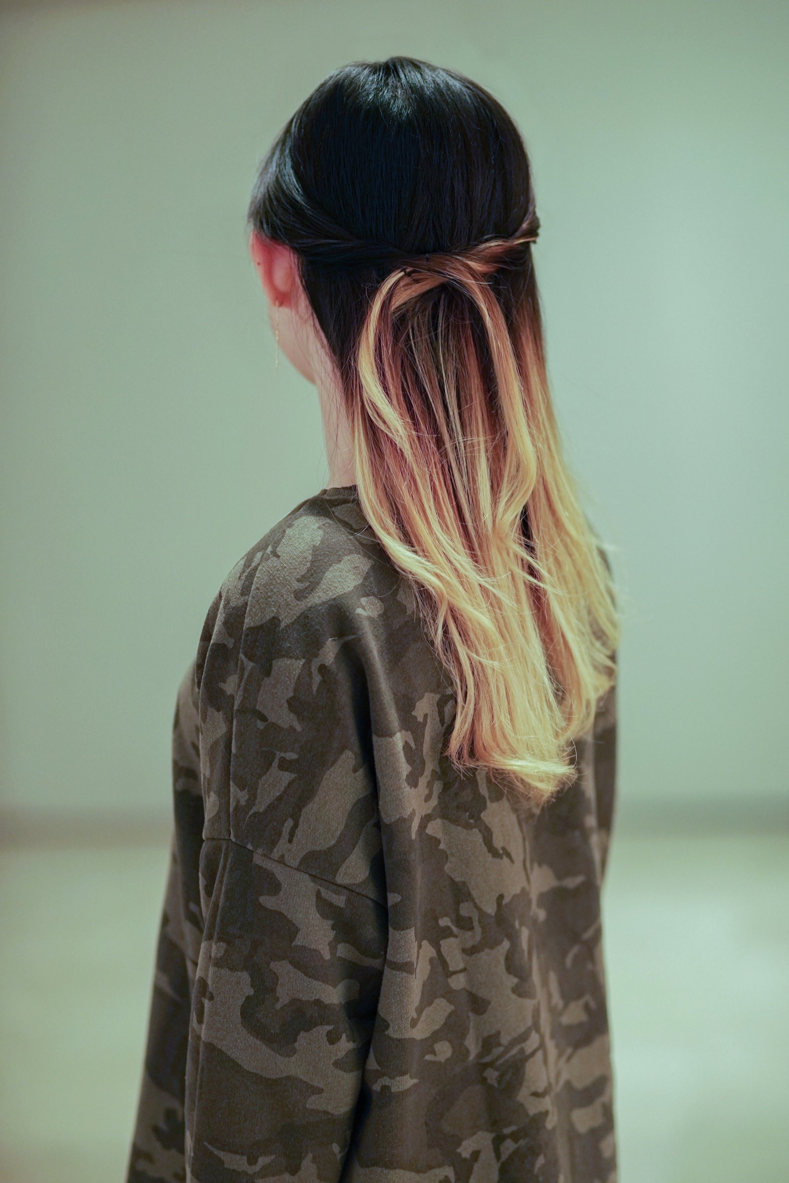 Back on an Asian woman with dark to blonde ombre hair