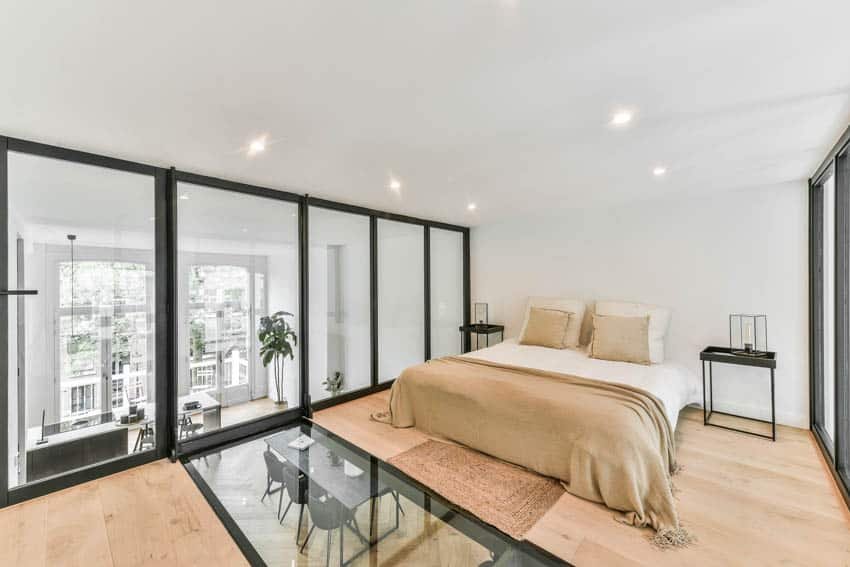 Bedroom with colorful gold blanket pillows wood floor and white wall
