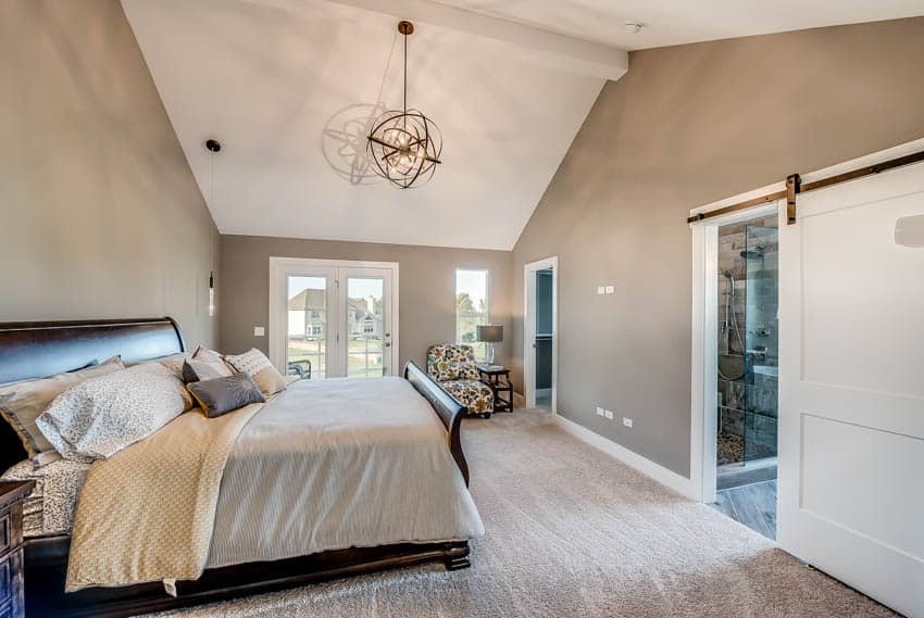 Bedroom with tan walls, gold hanging light